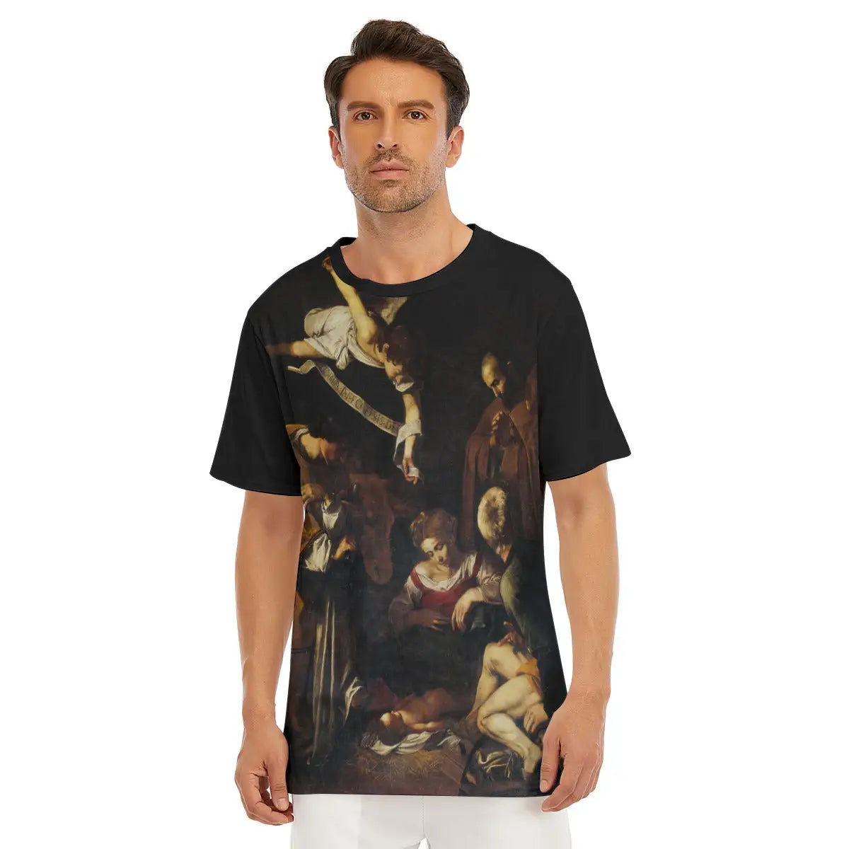Male model wearing the Nativity with Saint Francis and Saint Lawrence All-Over Print T-shirt showcasing Caravaggio's revolutionary sacred masterpiece with its dramatic chiaroscuro lighting illuminating the humble nativity scene and kneeling saints.