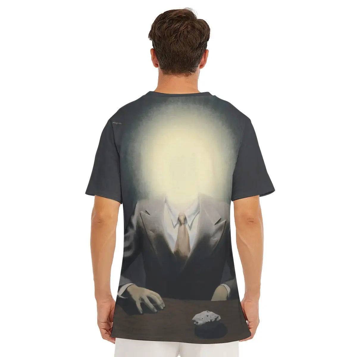 Male model wearing The Pleasure Principle by René Magritte All-Over Print T-shirt showcasing the surrealist portrait with its striking contrast between formal attire and the radiant light orb where the face should be