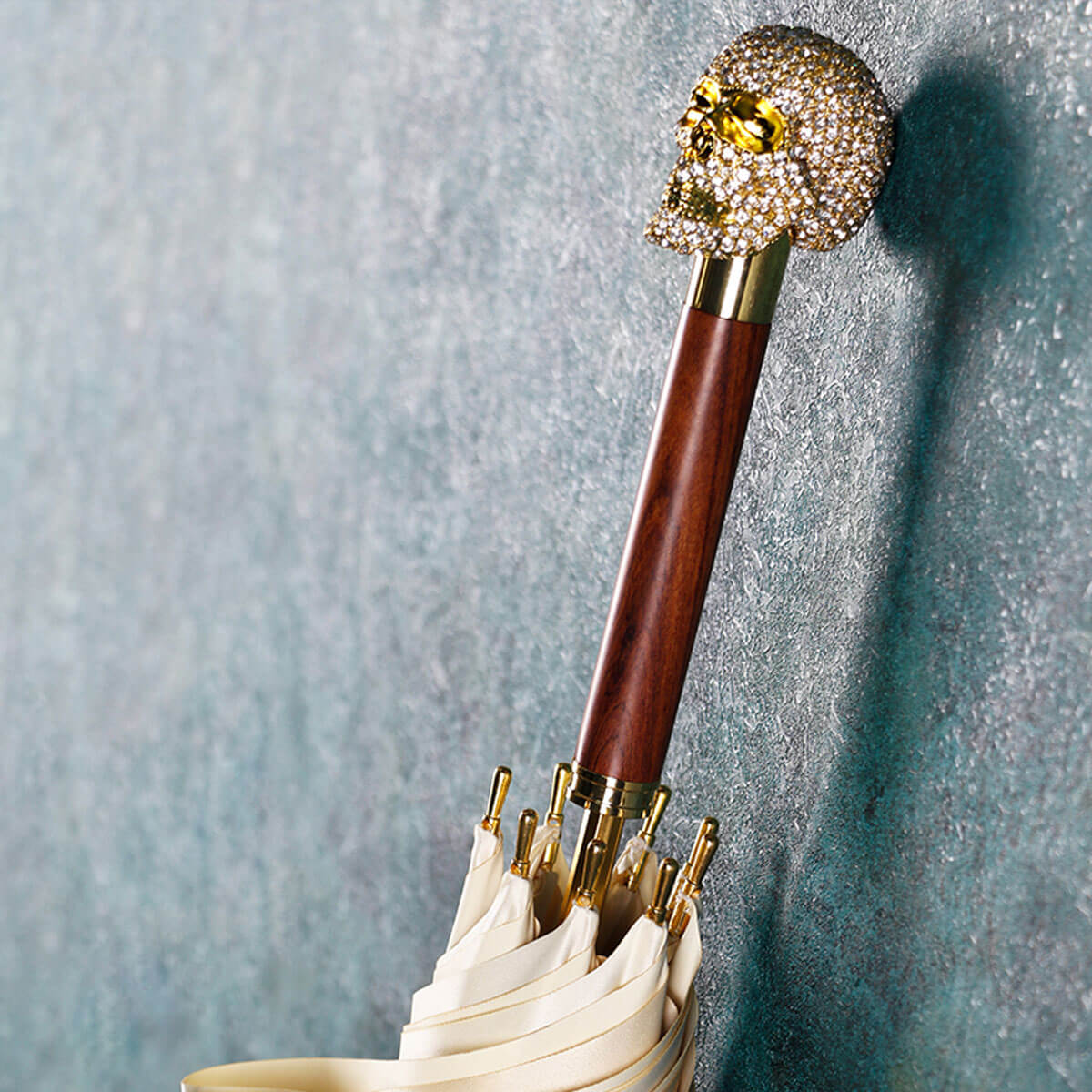 Elegant couple sharing large luxury umbrella with diamond skull in formal wear