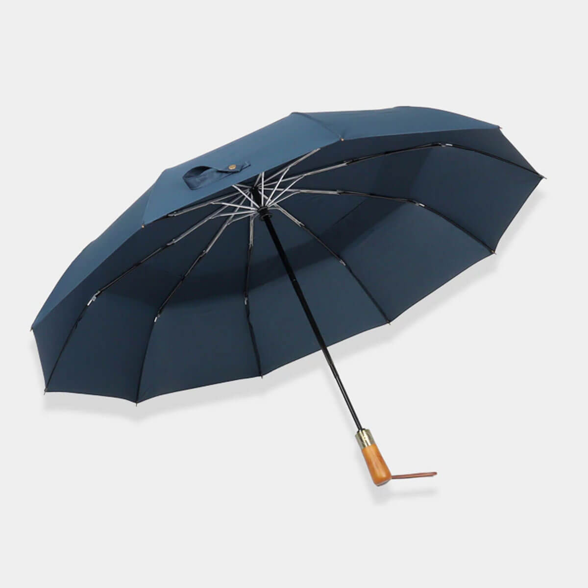 Grey automatic umbrella open against urban background