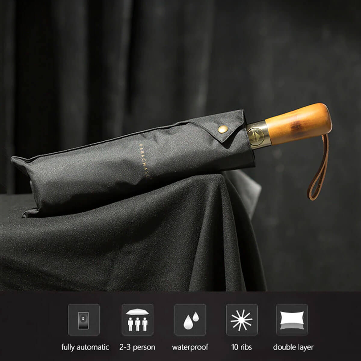 Black elegant umbrella repelling water droplets, showing weather resistance