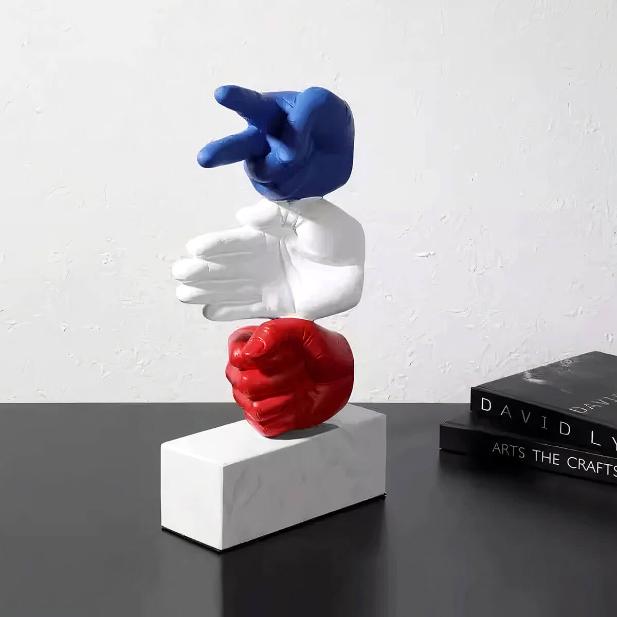 Trio of hand sculptures in white, representing Rock Paper Scissors game moves