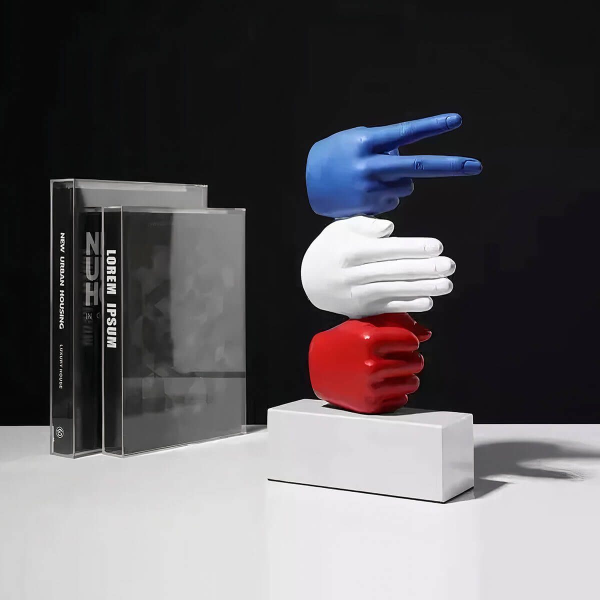 Red artistic hand gestures sculpture depicting Rock Paper Scissors game