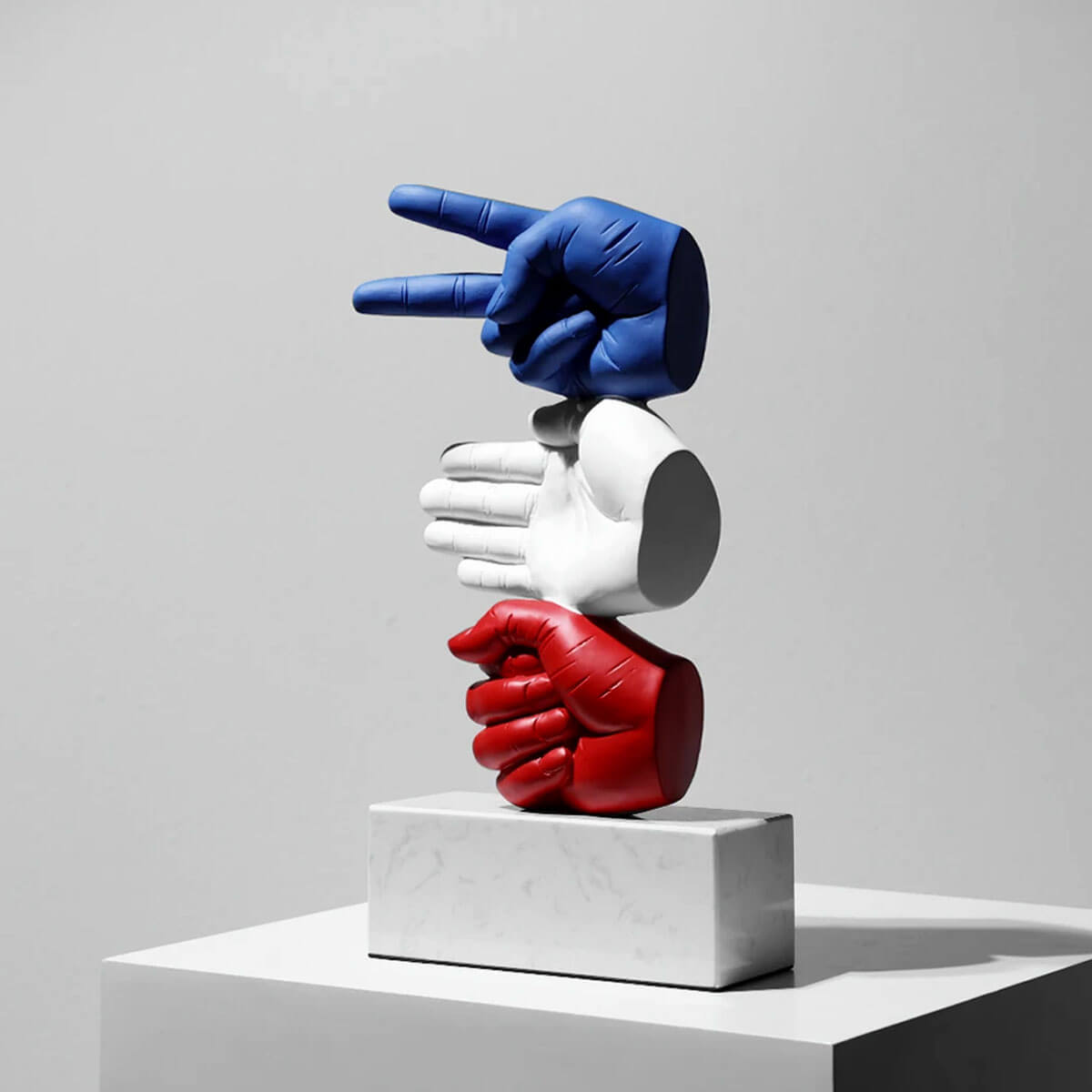 White sculptural representation of Rock Paper Scissors game with hidden meanings