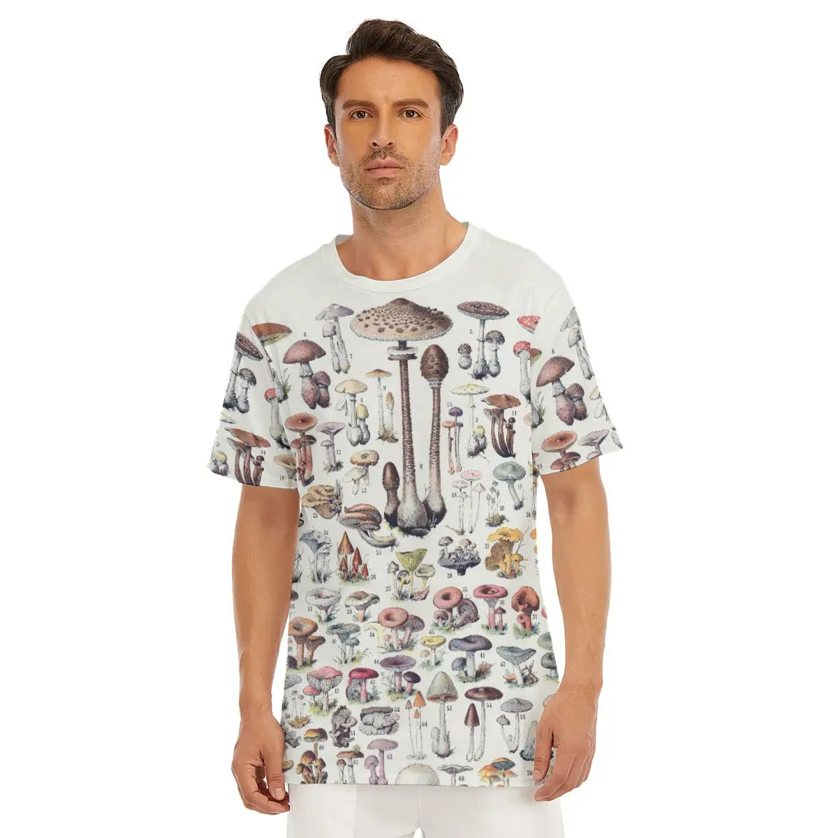 Male model wearing the Top Types Of Mushrooms All-Over Print T-shirt showcasing the meticulously illustrated collection of diverse mushroom species including Amanita muscaria, Porcini, Chanterelle, and other scientifically accurate fungi.